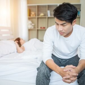 Man sitting on bed with erectile dysfunction